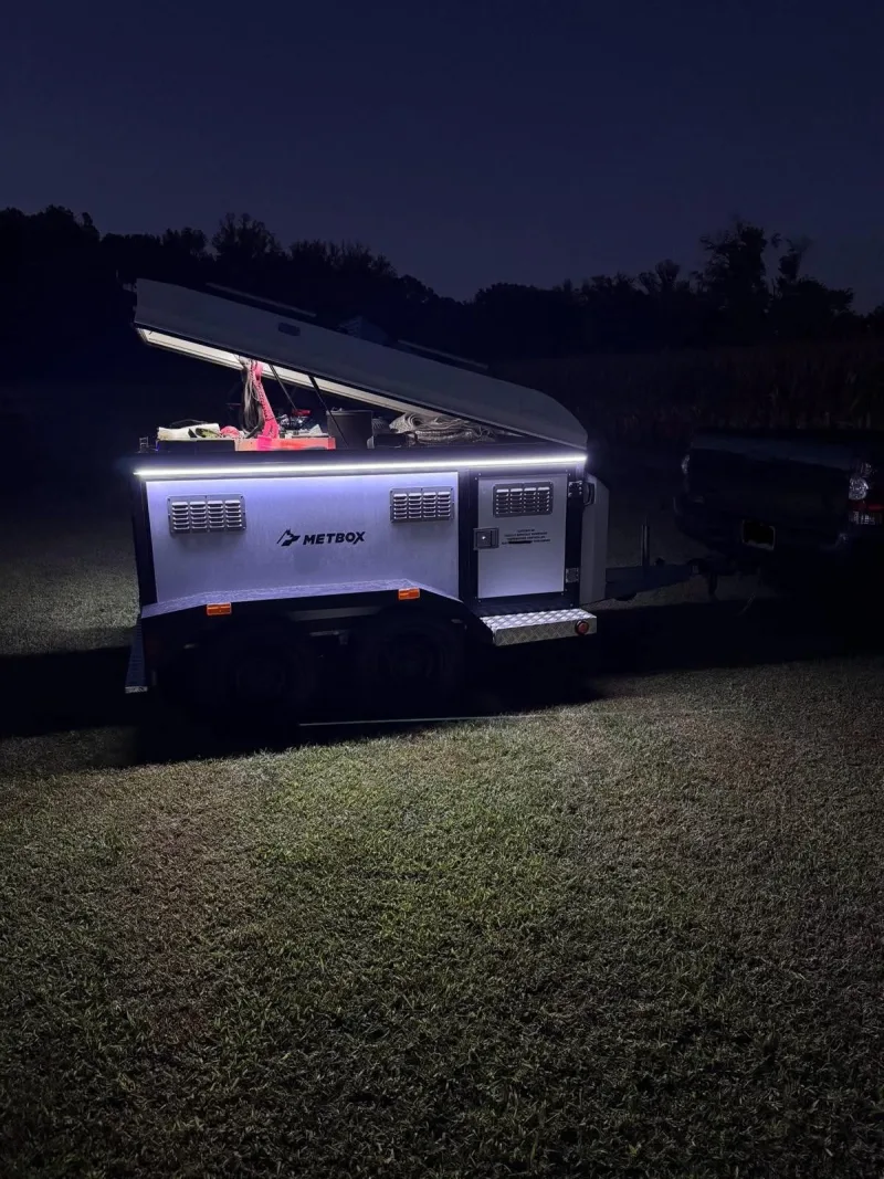 METBOX dog trailer at night with LED strip lighting and storage lid open