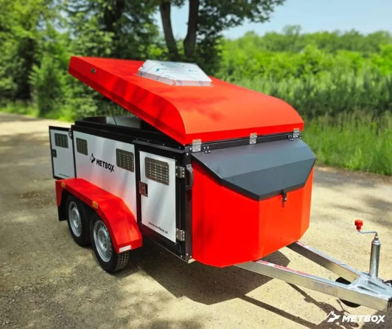 Red and white METBOX dual-axle dog trailer with hinged roof lid open and vented doors