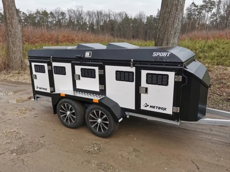 METBOX Sport white and black three-door dog trailer on a woodland track